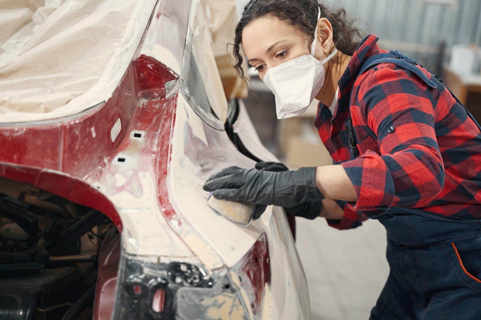 Car panel being sanded before painting